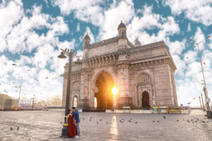 A couple is standing beside a pole i front of gateway of india blog